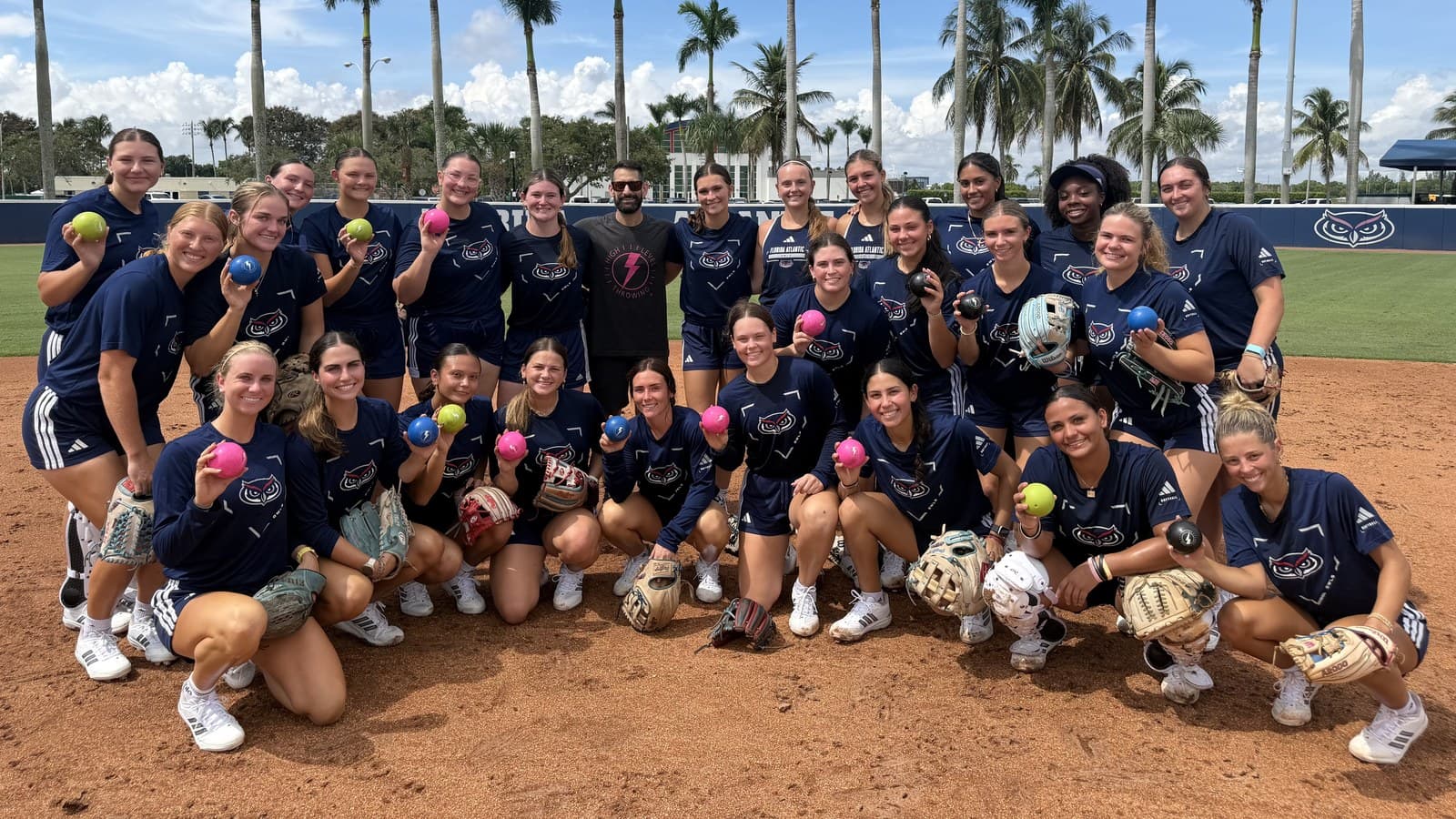 The FAU Softball roster holding up their Lightning Ball plyos with Austin Wasserman