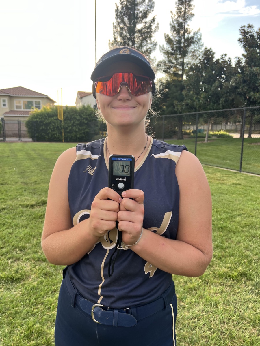 Softball athlete holding a radar reading 70 mph after a High Level Throwing clinic