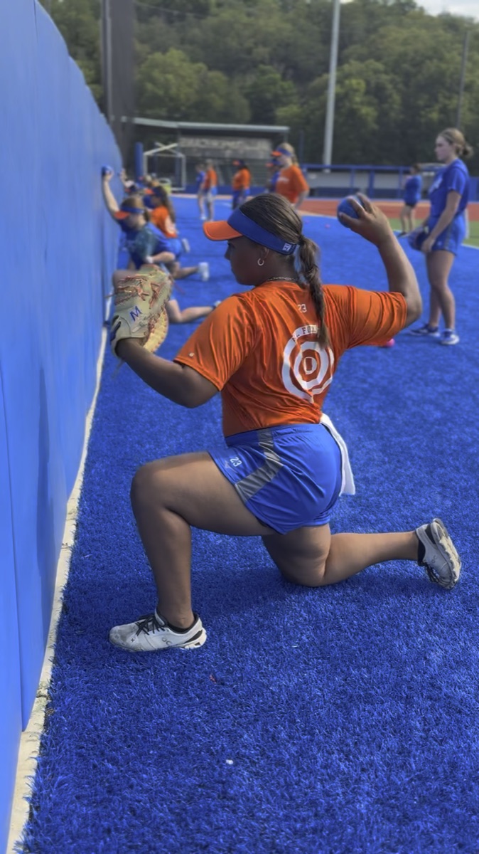 Softball athletes performing the High Level Throwing wall tap drill at a clinic