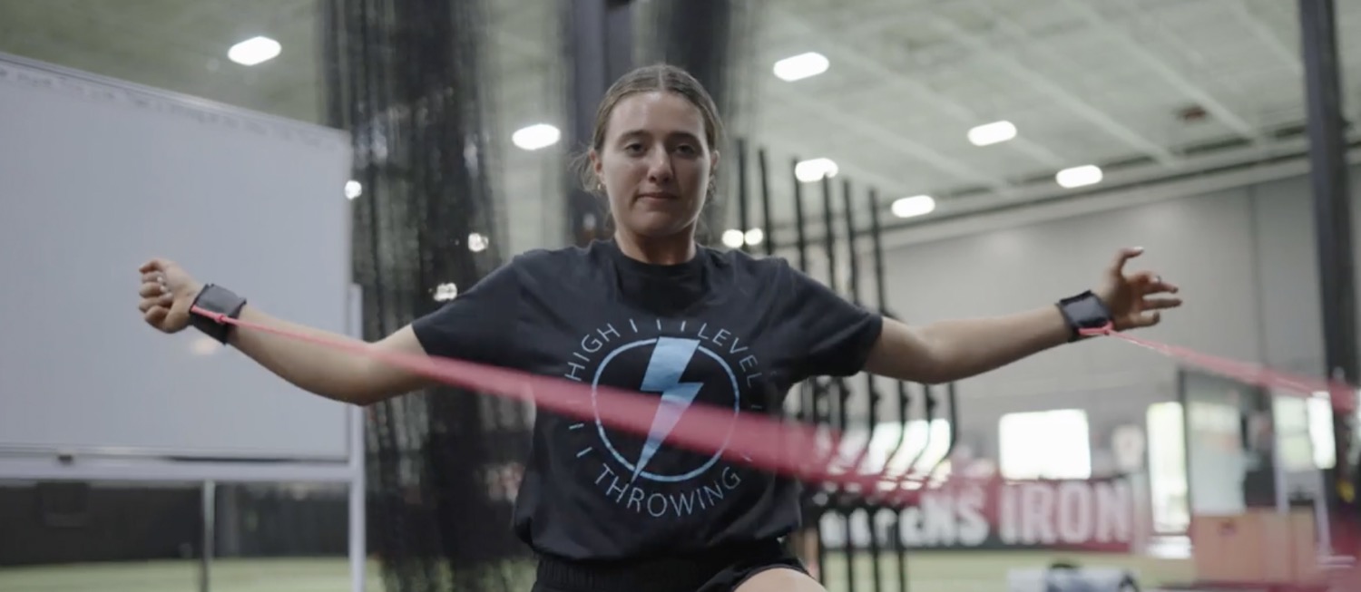 Athlete working through a scapular band drill with the arms wide