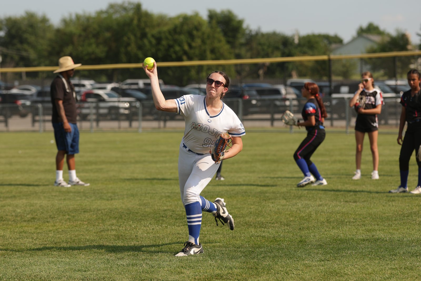 Athletes throwing on a field while coaches watch at a showcase event